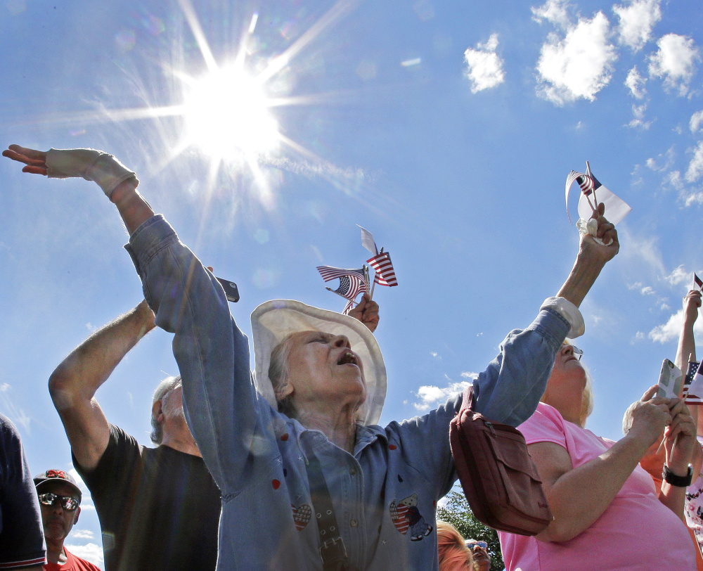 Ernestine Cuellar of Boston raises her hands in prayer. A recent Pew poll found 32 percent of respondents think one must be Christian to be an Americans.