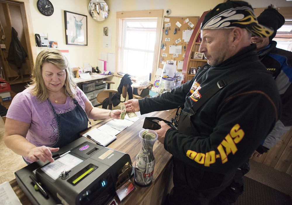 Terry Hill rings up several snowmobilers who stopped by her family's Mount Chase restaurant in early January to gas up their machines and eat. Hill, who originally opposed the Katahdin Woods and Waters National Monument, said visitors started coming up to the area almost immediately after the monument was created.