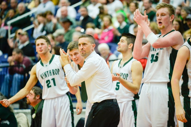 Winthrop Coach Todd MacArthur and his team celebrate in the fourth quarter of the Class C North boys' basketball semifinal game against NYA on Thursday. The Ramblers won 52-29.