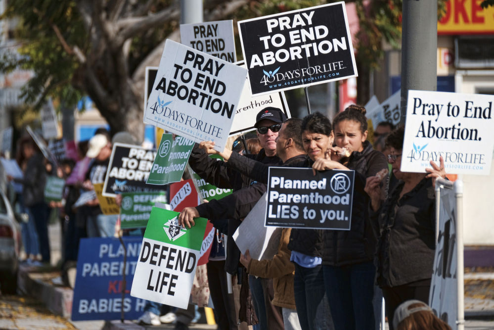 Protesters calling for Planned Parenthood to be stripped of its federal funding carry signs outside a Van Nuys, Calif., Planned Parenthood health center Feb. 11. A reader questions criticism of Planned Parenthood and other organizations that help women prevent unwanted pregnancies.