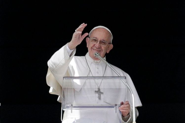 Pope Francis waves to faithful after delivering the Angelus prayer  in St. Peter's Square at the Vatican on Sunday.