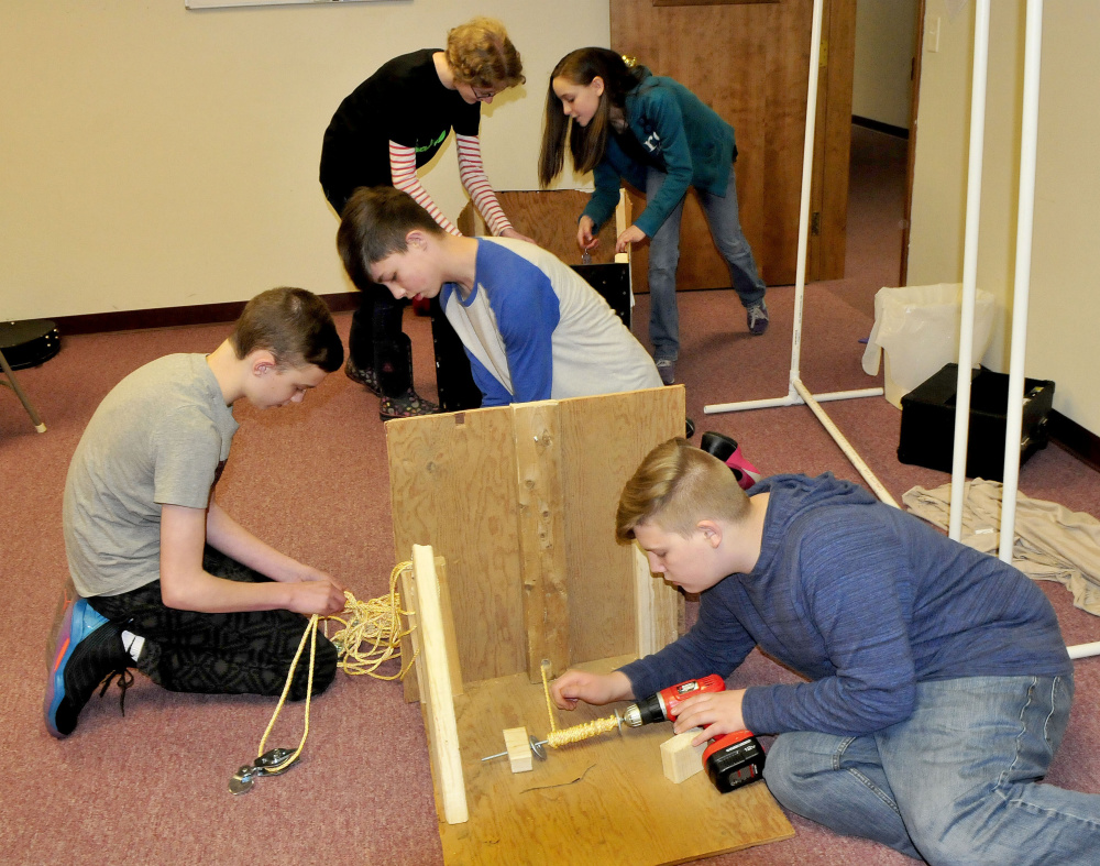 Students from the Somerset Homeschool Co-op assemble their team Infinite Velocity entry that earned them a state championship in an academic challenge competition Wednesday. They will compete for a national title in Tennessee. Sarah Hatfield, left, and Mackenzie Merrill work on the vehicle as Isaiah Simoneau, Ashton Umbrianna and Carter Houle assemble the ropes and winch that pulled the vehicle.