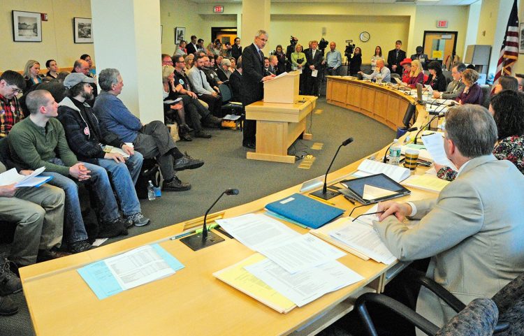 As a standing-room-only crowd looks on, Sen Roger Katz introduces "An Act To Restore the Tip Credit to Maine's Minimum Wage Law" during a hearing of the Labor, Commerce, Research and Economic Development Committee on Wednesday.