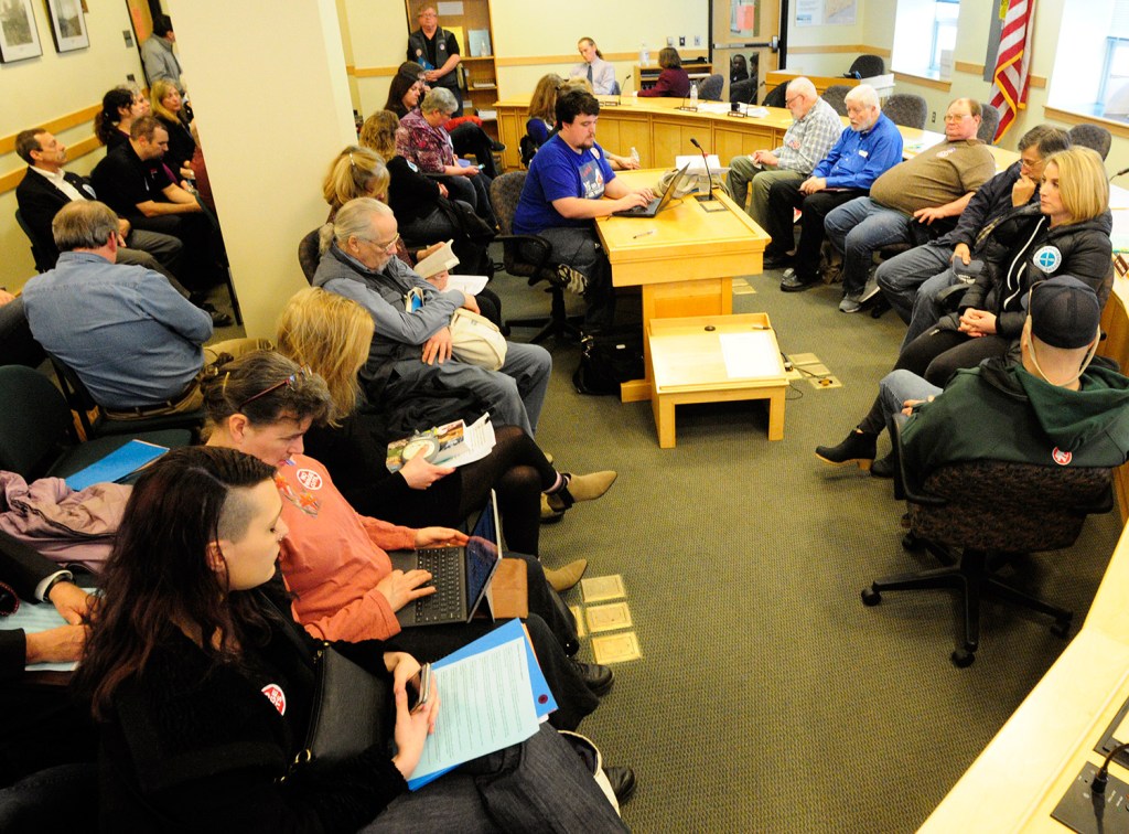 People sit in a nearby room waiting to testify Wednesday before the Labor, Commerce, Research and Economic Development Committee on two tip credit bills.