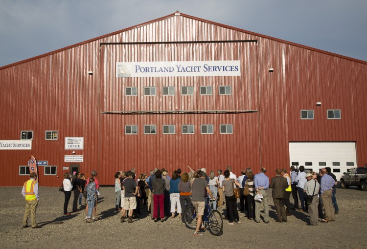 Portland Planning Board members and others get a tour in May on the waterfront site where a proposed cold storage facility would be built. The nearby Portland Yacht Services building was used to compare what the height of the proposed building might look like.