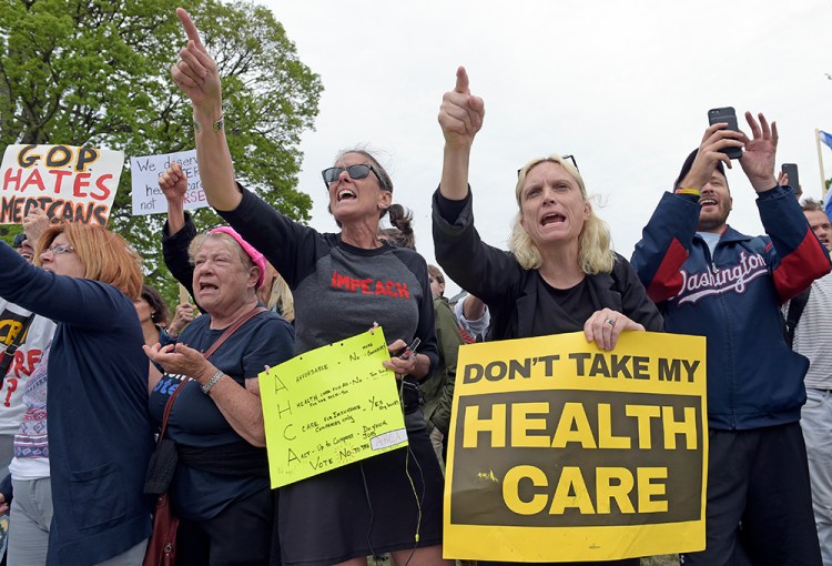 Protesters chant as Republican and Democratic House members walk down the steps of the Capitol  Thursday, after the Republican health care bill passed in the House. 