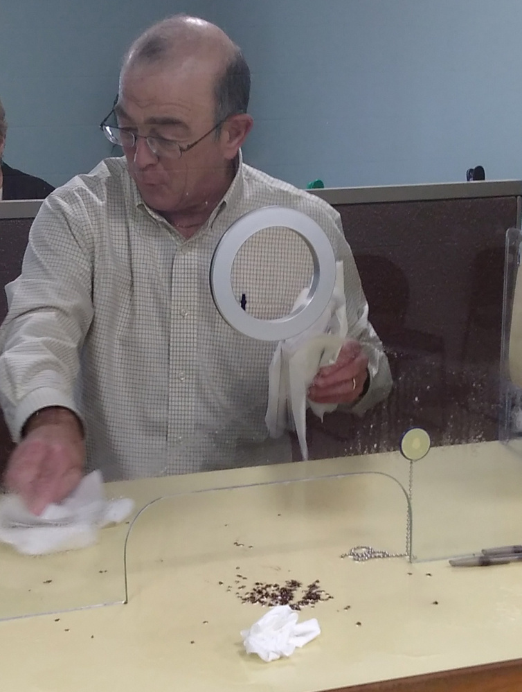 Ralph St. Pierre, Augusta's finance director and assistant city manager, picks up bedbugs ostensibly spilled by a disgruntled man Friday at Augusta's City Center.