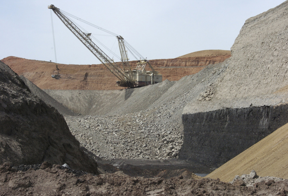 An excavator moves rocks above a coal seam at the Spring Creek Mine in Decker, Mont., in 2013. President Trump has ordered a review of the Clean Power Plan, which targets emissions from coal power plants, and lifted a moratorium on sales of coal mining leases on federal lands.