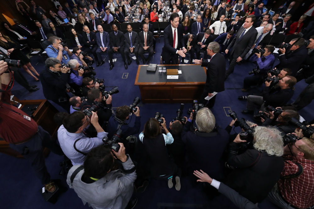 Former FBI director James Comey is greeted by Senate Intelligence Committee Chairman Richard Burr, R-N.C. at the beginning of the Senate Intelligence Committee hearing on Capitol Hill on Thursday in Washington.