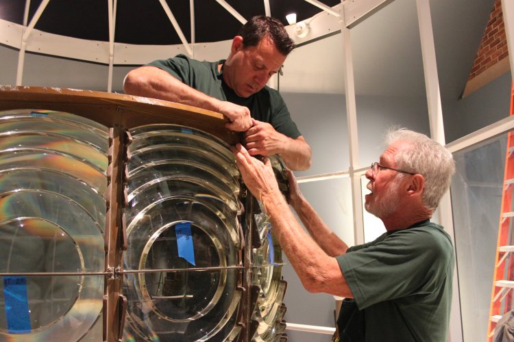 Tommy Cumella works inside Cape Elizabeth Two Light’s second-order Fresnel lens as Jim Dunlap makes sure there’s no risk of the lens falling. 