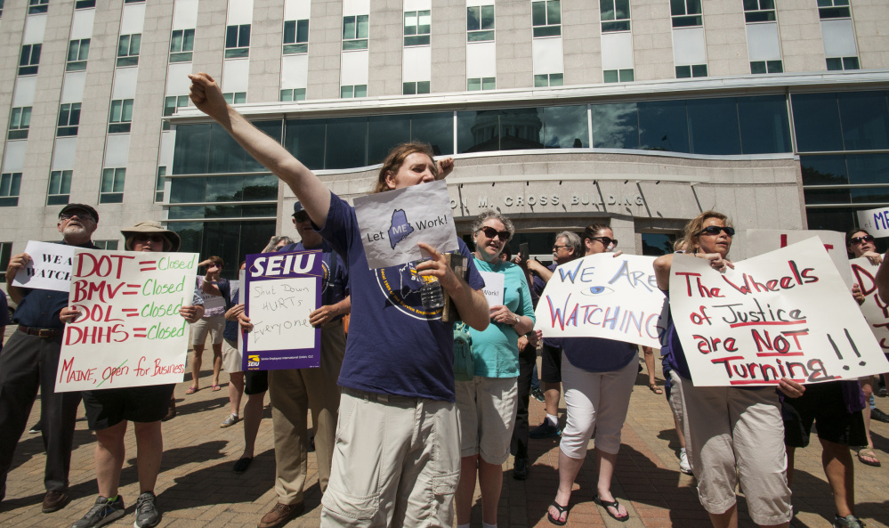 State employee union members protest the state shutdown by rallying Monday in front of the Burton Cross State Office Building in Augusta.