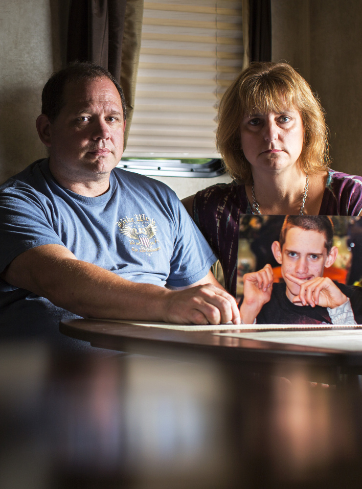 Wayne LaPointe and Terri Earley of Topsham hold a portrait of their autistic son, Bradley, who died in a group home in October. He was 22 years old.