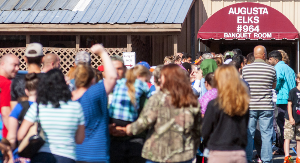 A line stretches across the parking lot at the Augusta Elks Lodge before the door opened for the backpack and school supplies giveaway on Saturday.