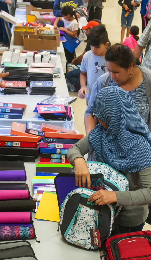 People choose backpacks and other school supplies Saturday at a giveaway at the Augusta Elks Lodge.