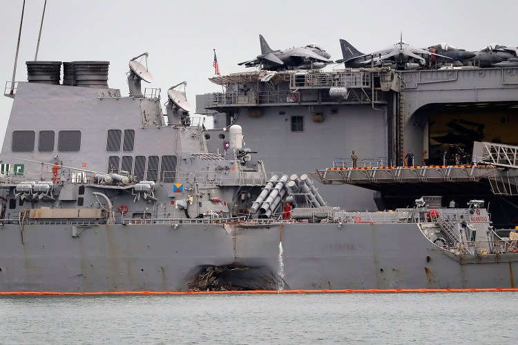 The damaged hull of the USS John S. McCain is seen at Singapore's Changi naval base on Aug. 22. The ship's top two officers were fired Tuesday because of the fatal collision, which officials said was preventable.