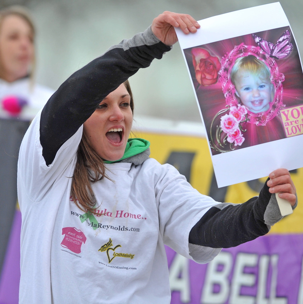 Trista Reynolds, mother of missing toddler Ayla Reynolds, holds a picture of her daughter at the Colby Circle College Avenue intersection in Waterville.