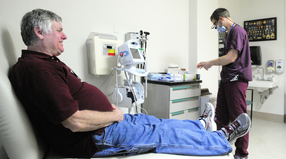 Army veteran Tom Baker meets with Dr. Alex Gale, a dental resident, as he prepares to perform a free oral cancer screening. Staff photo by Joe Phelan