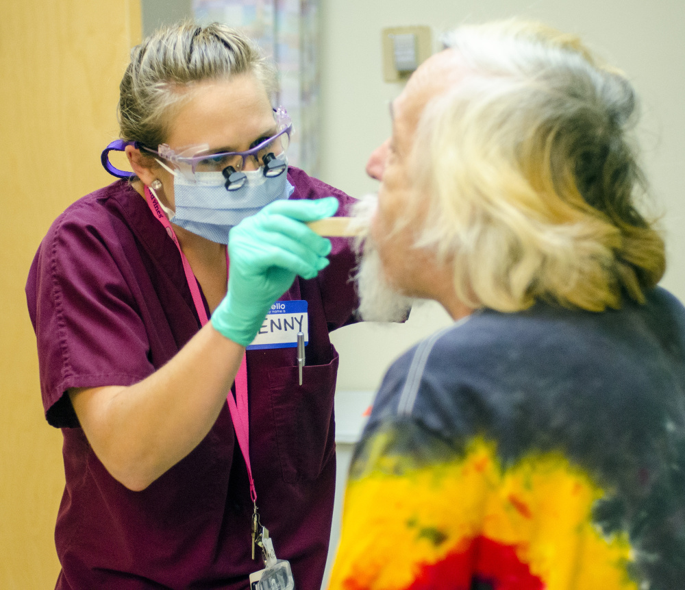 Dr. Jenny Miedema, a dental resident, screens Anthony Ward of Lewiston for oral cancer. Staff photo by Joe Phelan