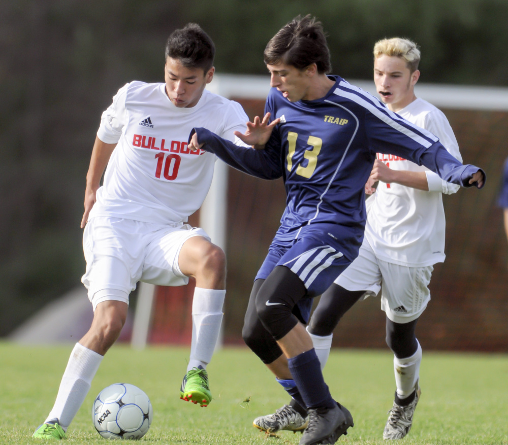 Akira Warren, left, of Hall-Dale tries to shield the ball from Traip Academy's Jacob Gagner during a Class C South boys' soccer semifinal Saturday in Farmingdale. Seventh-seeded Traip advanced with a 2-0 victory.