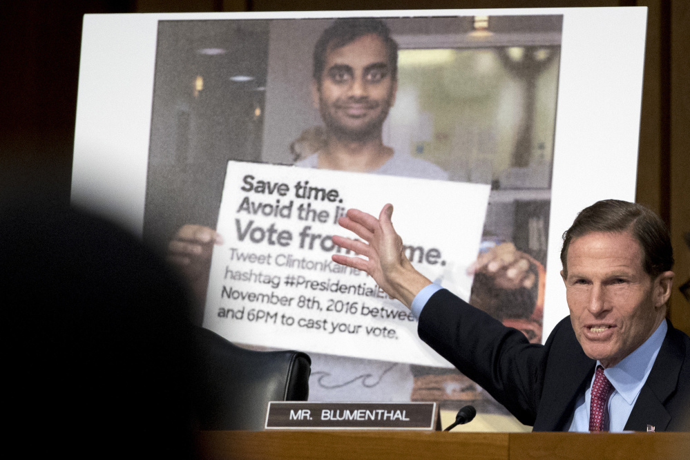 Sen. Richard Blumenthal, D-Conn., talks about a poster depicting an online ad that attempted to suppress voters as representatives from Facebook, Twitter and Google testify before a Senate subcommittee on crime and terrorism on Capitol Hill in Washington on Tuesday.