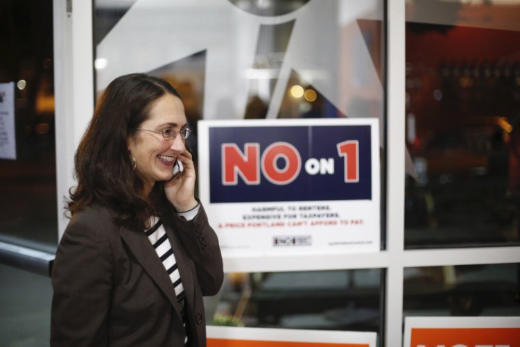 Yasmin Vitalius, the wife of the spokesman for Say No To Rent Control, talks on the phone at an election results gathering Tuesday.