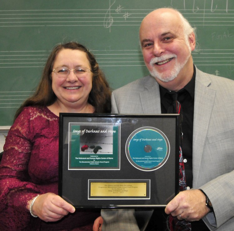 Messalonskee High School Concert Chorus co-directors Pam and Kevin Rhein show copies Thursday of "Songs of Darkness and Hope," performed by Messalonskee students, which is nominated for a Grammy Award in the choral category.