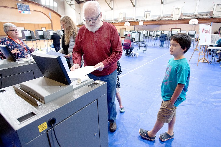 Jon Pitman casts his ballot at the Lewiston Memorial Armory on Tuesday. Pitman's grandchildren, Kazuchi and Ayana Suzuki, came with him.