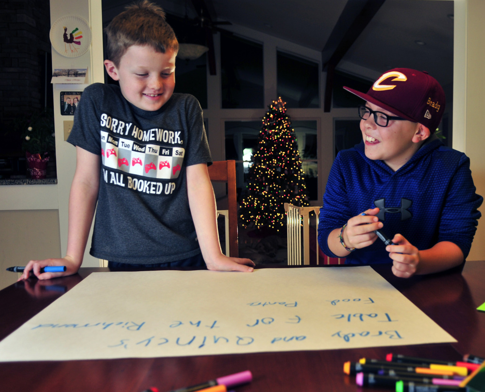 Quincy Emmons, left, and Brady Alexander work on a poster Thursday. They will staff a table Friday at the Richmond tree-lighting to collect for the Richmond Food Bank.