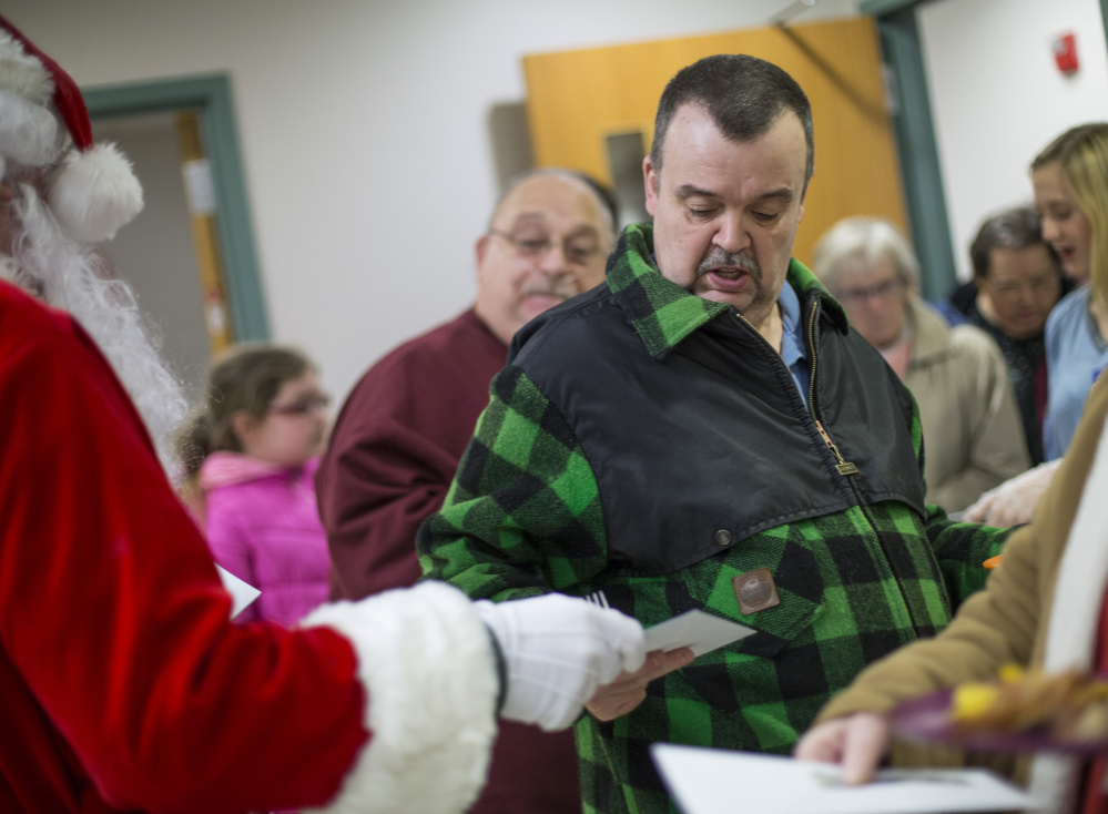 Leo Carrier of Standish gets a $100 bill from the Secret Santa.