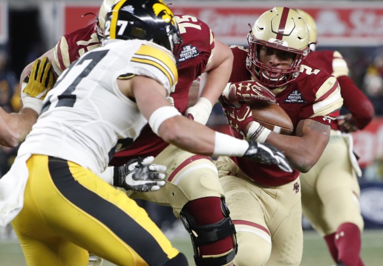 Iowa safety Amani Hooker, left, looks to tackle Boston College running back AJ Dillon on a 39-yard catch and run during the Pinstripe Bowl Wednesday in New York, where the kickoff temperature was 23 degrees.