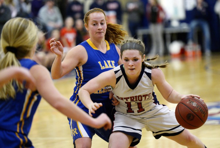 Gray-New Gloucester's Alexa Thayer drives with the ball as Bella Russo of Lake Region moves in on defense during the Patriots' 42-41 win Tuesday in Gray.