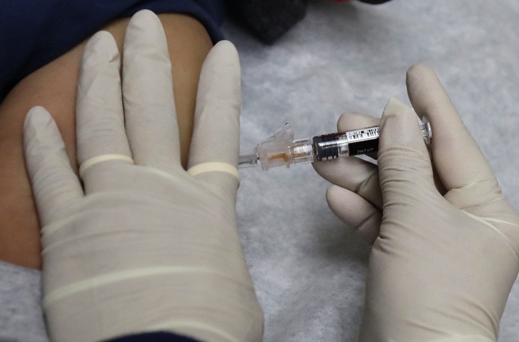 Experts recommend getting a flu shot, but say it isn't yet clear how effective the vaccine is this season. Center, gives a patient a flu shot in Seattle. Flu season continues to get worse, as this has become the most intense the country has seen since a pandemic strain hit nine years ago, U.S. health officials said on Friday, Jan. 26, 2018. (AP Photo