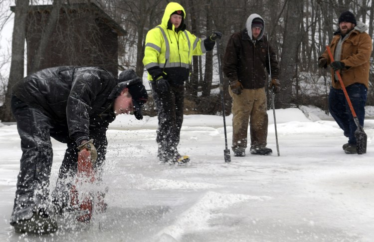 Richard Potter saws holes through ice Tuesday on the Kennebec River at his business, Baker's Smelt Camps, in Pittston. The Coast Guard's inability to break up the river has permitted Baker's to put shacks back on the ice for fishing. "We hope to have them all out by tomorrow," Potter said, "and rented."