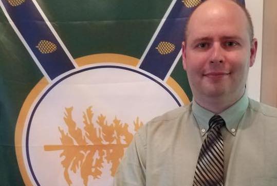 Jackman Town Manager Tom Kawczynski poses in front of his New Albion flag.