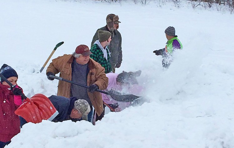 This photo posted on Facebook by Barbetta Ann Bowker Turner shows passersby on Route shoveling out the baby moose.