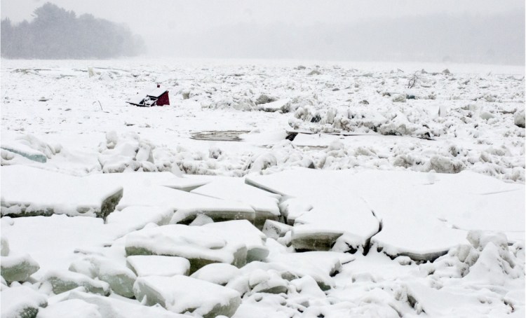 A dumpster that floated away on the Kennebec River during a Jan. 14 flood lies stuck in the ice in Hallowell.