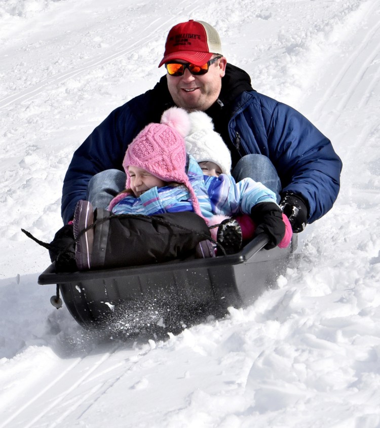 Jude Violette takes his girls Avery, front, and Brooklyn for a fast ride down the sledding hill at the Quarry Road Recreation Area in Waterville during the Winter Fun Day on Sunday. Families went cross-country skiing, tried snowshoeing, sledded, played games, socialized and had snacks.