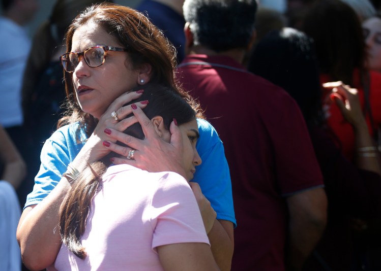 Mourners comfort each other Thursday at a prayer vigil at the Parkland (Fla.) Baptist Church for the victims of the shooting at Marjory Stoneman Douglas High School. Readers say it’s past time to take action that will prevent such school shootings.