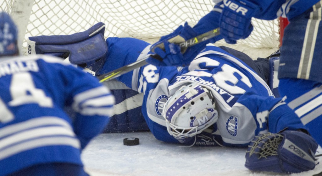 Colby College goalie Sean Lawrence (33) makes a save on a shot from the University of New England in the third period Saturday in Biddeford.