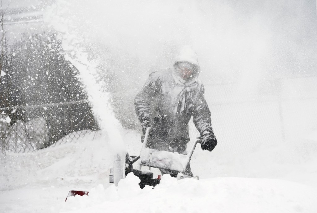 Kyle Binette feels the brunt of the storm as he clears snow from his driveway in Biddeford. Winds were gusting over 35 mph Tuesday.