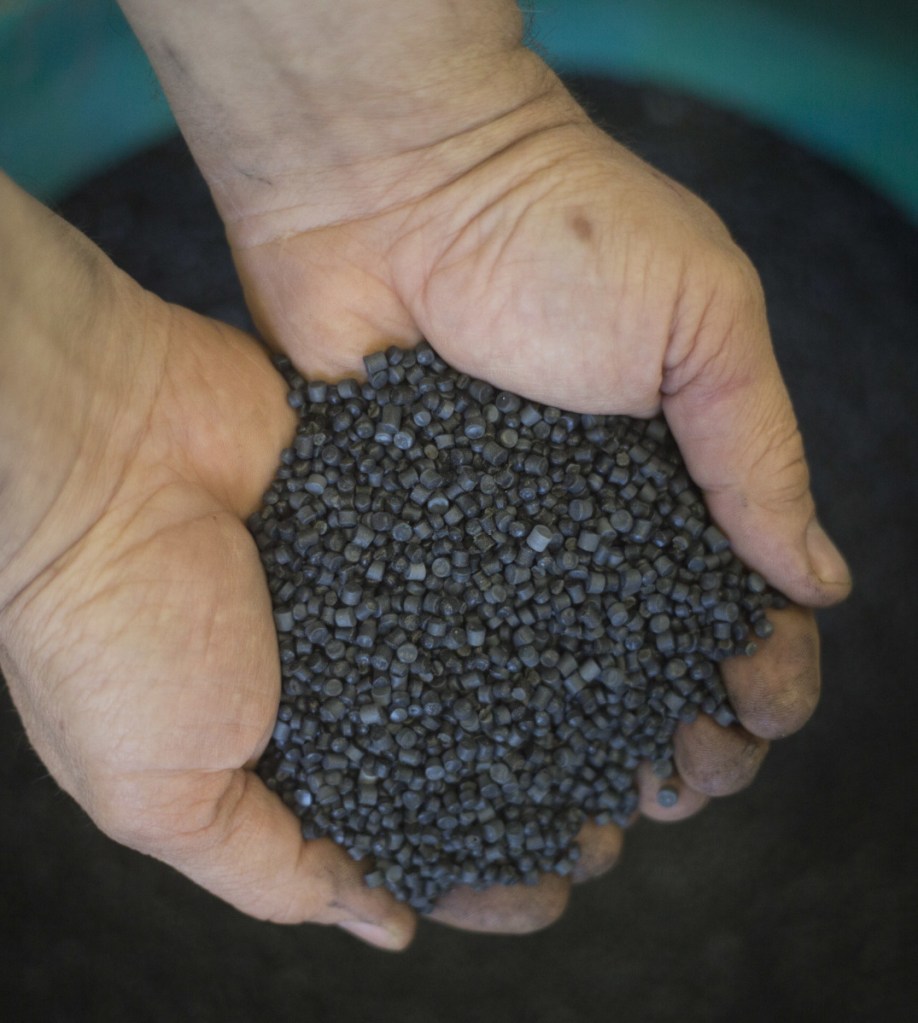 A worker holds bio-based thermoplastic composite made from municipal solid waste material in Israel.