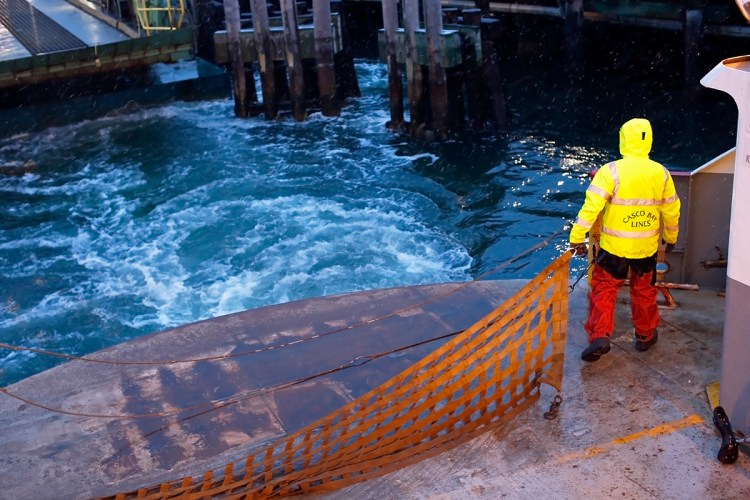 Colin Anderson, a mate for Casco Bay Ferry Lines, fastens a cargo net across the stern of the Machigonne II after departing Portland for Peaks Island on Wednesday, before expected snow.