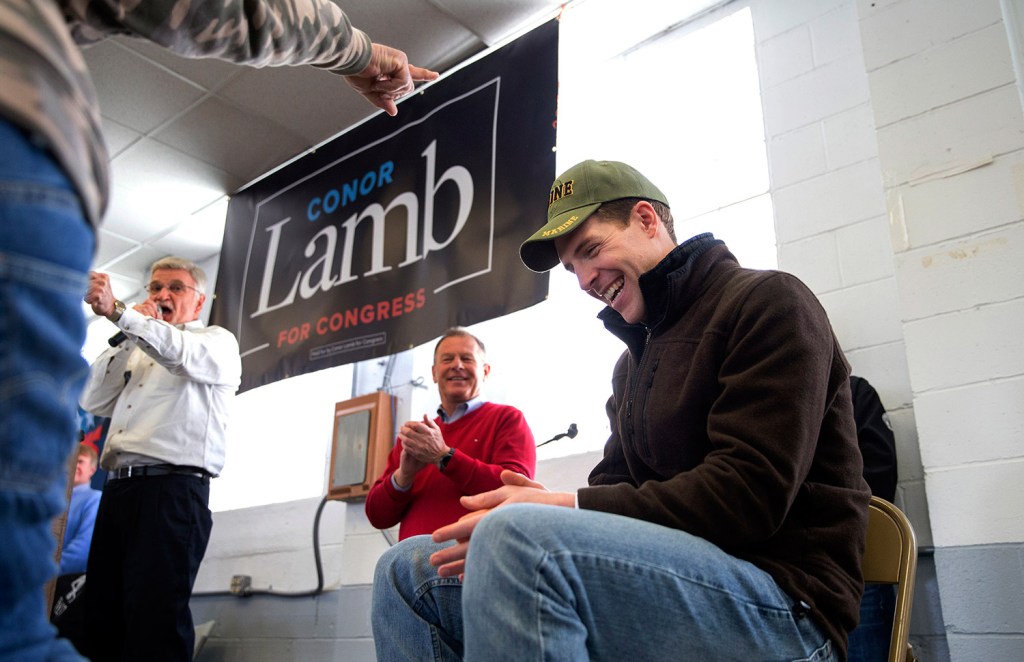 Retired coal miner David Fibazzo, left pointing, of Coal Center, places his hat on top of Democratic candidate Conor Lamb's head during a rally with the United Mine Workers of America on Sunday at the Greene County Fairgrounds in Waynesburg, Pa. Lamb was asking Pennsylvania's coal country for help in the first congressional election of 2018, viewed as a key test of support for Republicans ahead of November's midterms. 