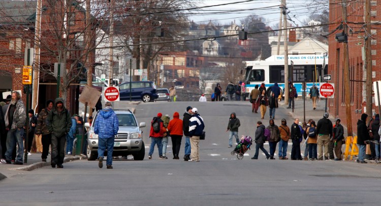 People gather on Oxford Street outside the Preble Street Resource Center, right, and Oxford Street Shelter, the white building several blocks away on the left. The party atmosphere and loitering outside the shelters have caused challenges for Bayside residents. 