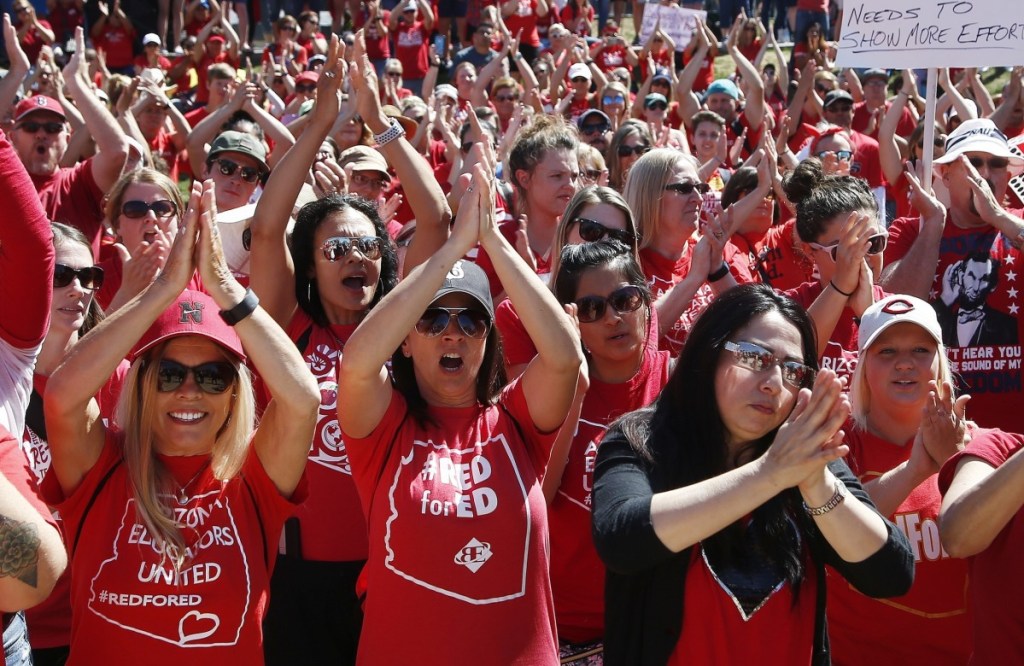 Teachers chant Thursday at the Arizona Capitol in Phoenix. After an all-night legislative session, lawmakers passed the new education spending portion of the budget.