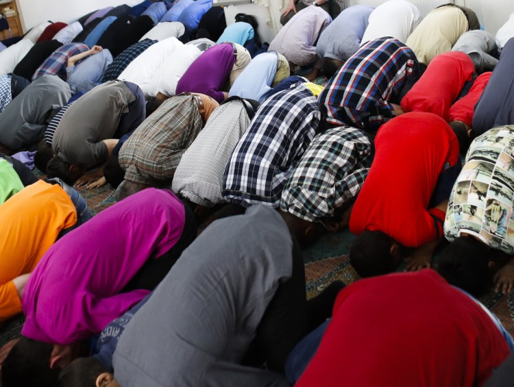 Muslims attend the morning prayer on the first day of the Islamic holiday of Eid al-Fitr, celebrating the end of the fasting month of Ramadan at a mosque in the Arab immigrant neighborhood of Neukoelln in Berlin, Germany.