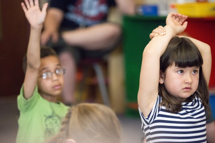 Samire Page, right, raises her hand to ask a question in Jen Morneault's first-grade class at Winslow Elementary School on May 18. 