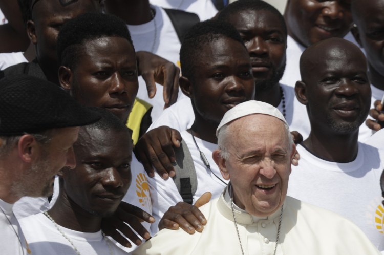 Pope Francis poses with a group of faithful as he leaves St. Peter's Square at the Vatican on Wednesday.