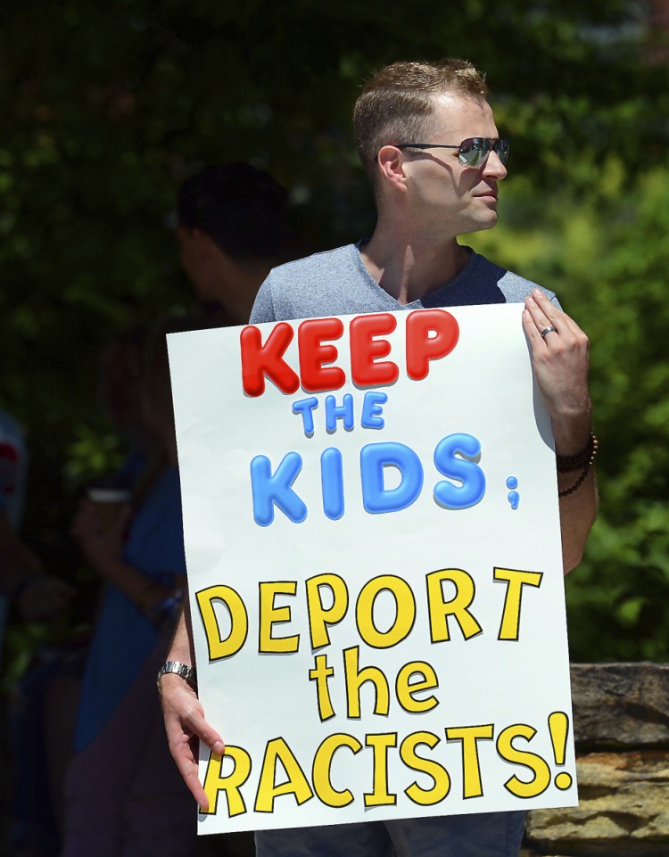 Chris Olson, 31, of Lake Wallenpaupack, Pa., holds a sign outside near Lackawanna College in Scranton, Pa.