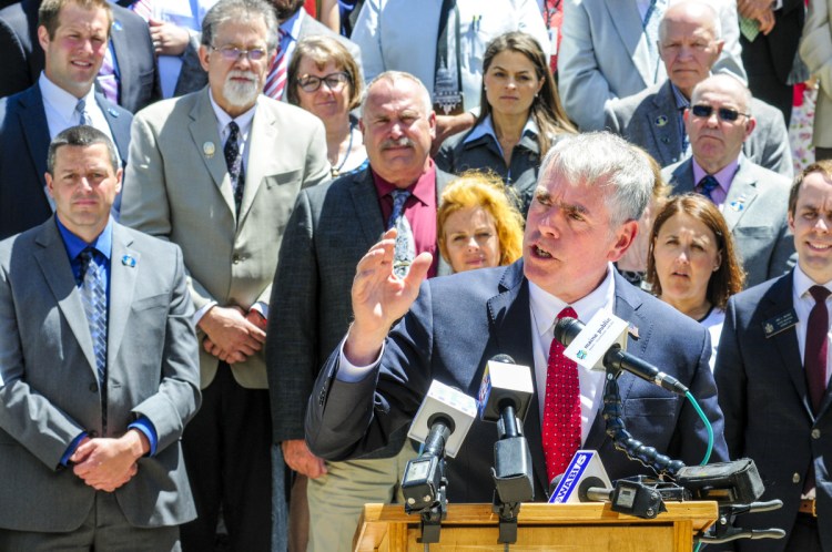 Republican lawmakers stand behind Shawn Moody, the party's candidate for governor, as he speaks during a Republican unity rally in Augusta on Tuesday.